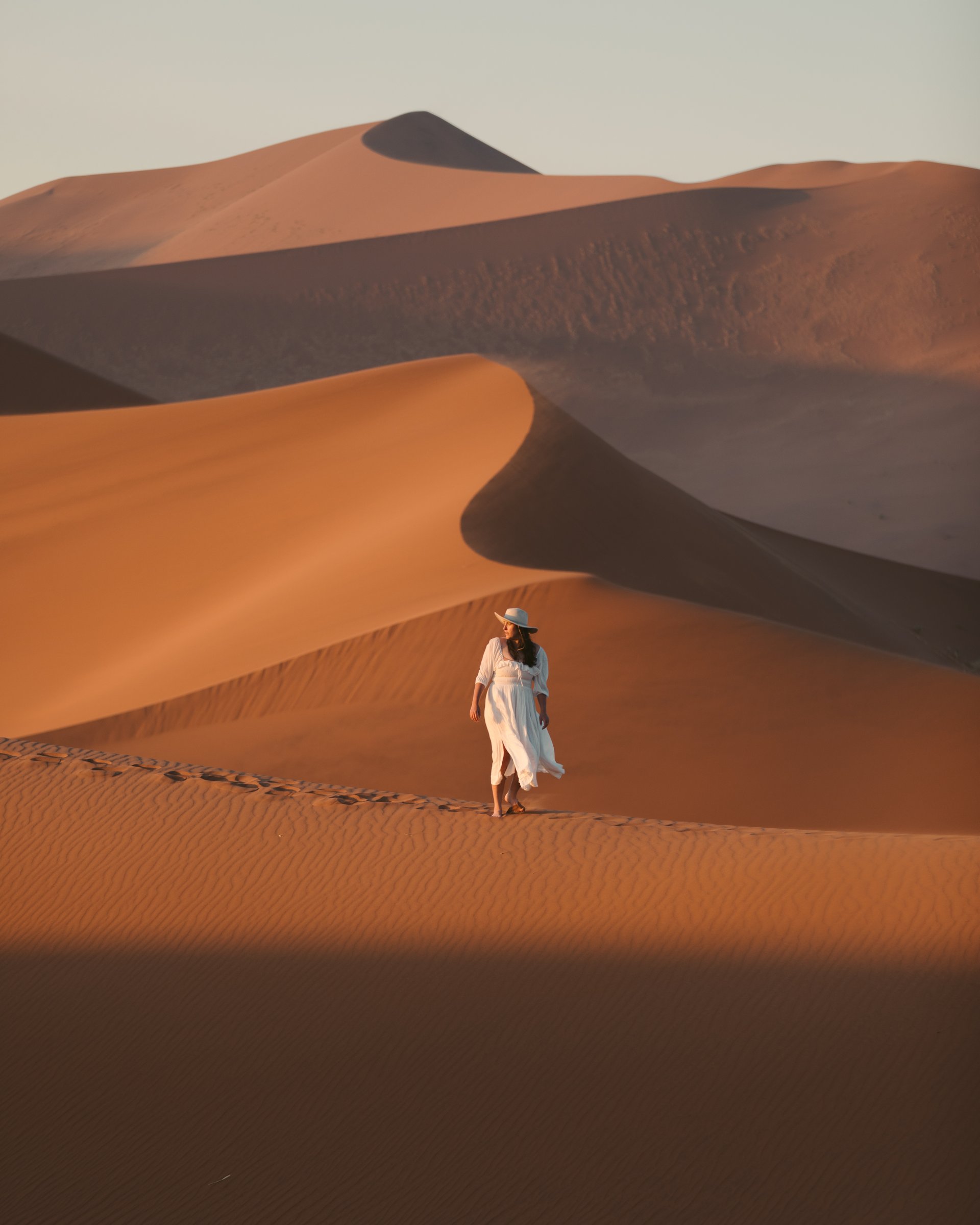 Emma walking the ridge of a Sossusvlei sand dune at golden hour, Namibia
